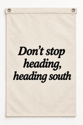 “Don't stop heading, heading south” canvas flag on a white background